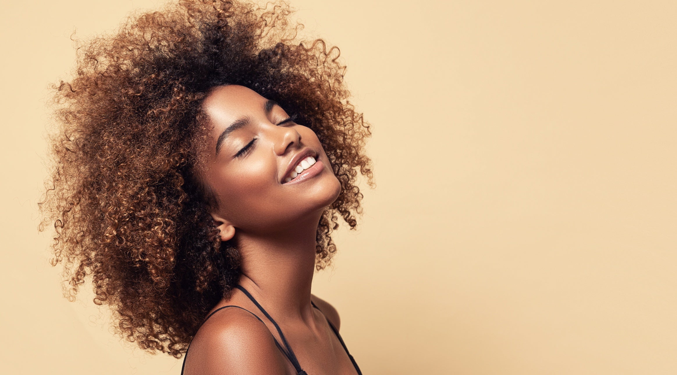 Photo d'une belle femme noire tête penchée en arrière les yeux fermés et souriante