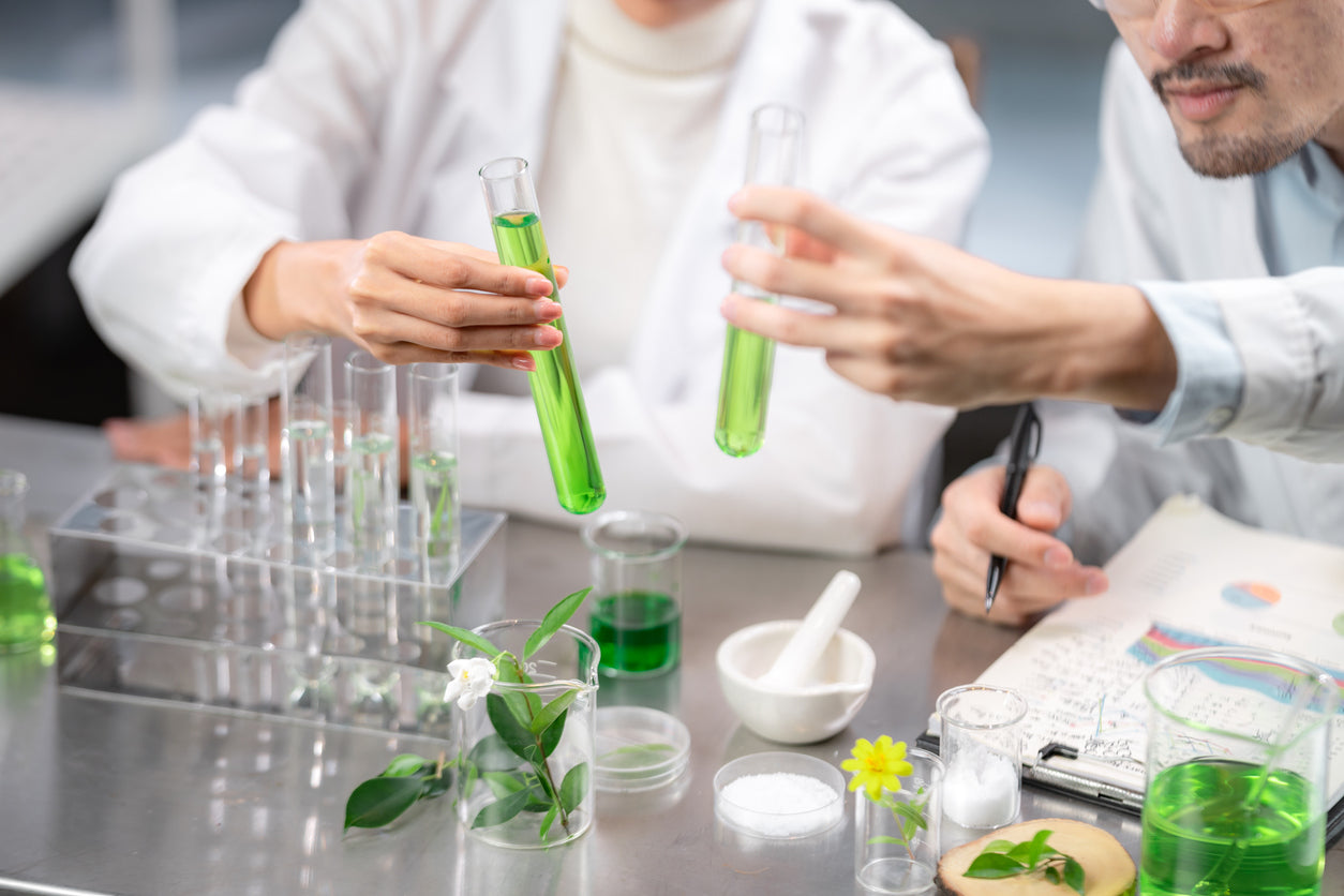 formulateurs en laboratoire comparant des éprouvettes d'actifs naturels