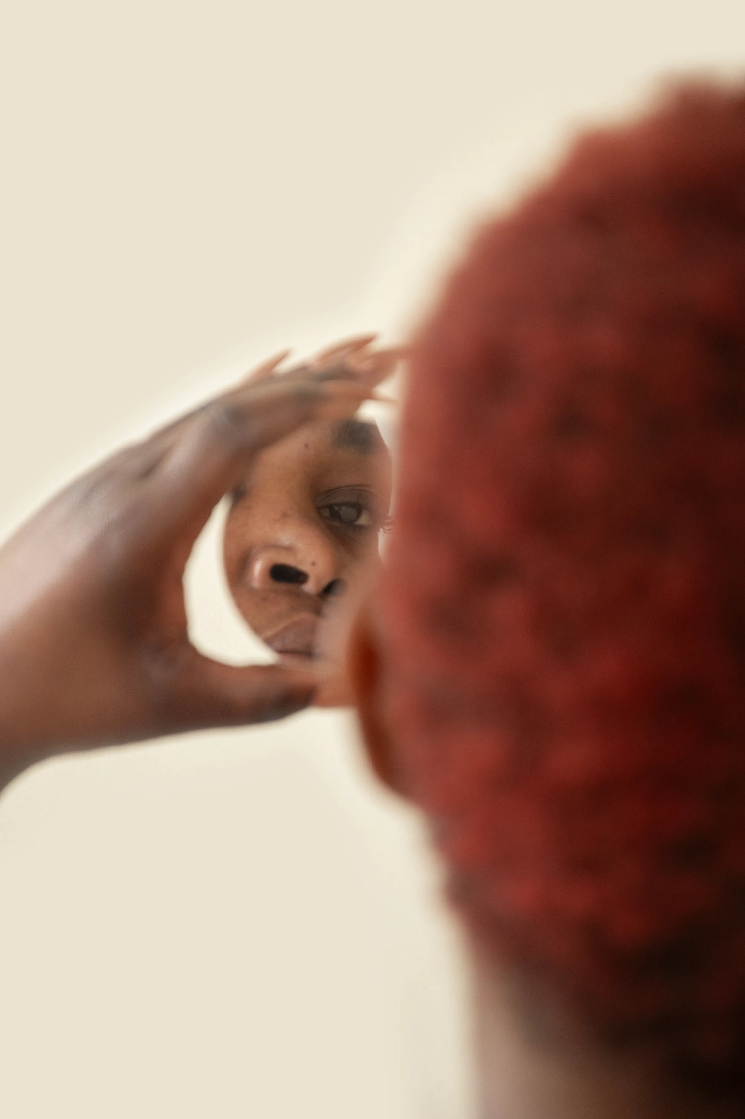 Femme peau noire observant des taches pigmentaires sur son visage dans le miroir